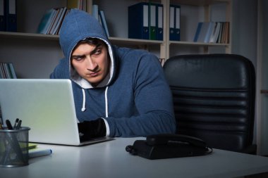 Genç hacker geceleri bilgisayarı hackliyor.