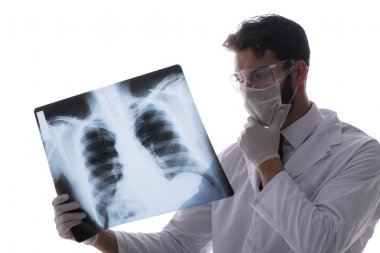 Röntgen görüntülerine bakan genç doktor beyazda izole edilmiş.