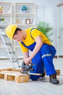 Ahşap palet montajı yapan genç adam.