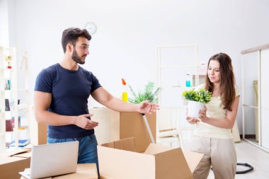 Young family unpacking at new house with boxes clipart