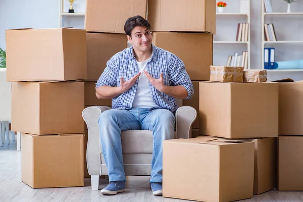 Молодой человек переезжает в новый дом с коробками — стоковое фото