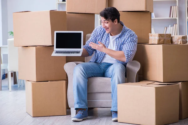 Молодой человек переезжает в новый дом с коробками — стоковое фото