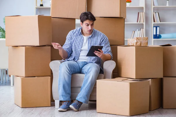 Junger Mann zieht mit Kisten in neues Haus ein — Stockfoto