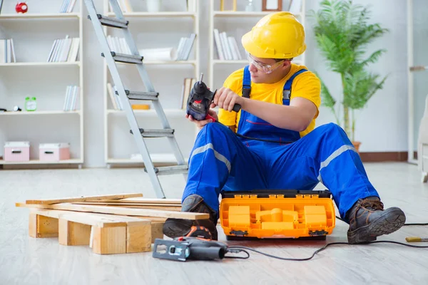 Jeune homme assemblant des palettes en bois — Photo