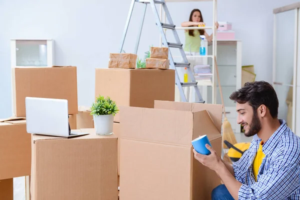 Familia joven desempacando en casa nueva con cajas — Foto de Stock