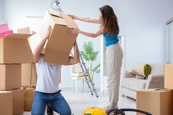 Familia joven desempacando en casa nueva con cajas — Foto de Stock