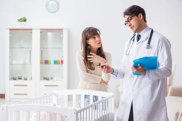 Doctor explaining to young mother — Stock Photo, Image