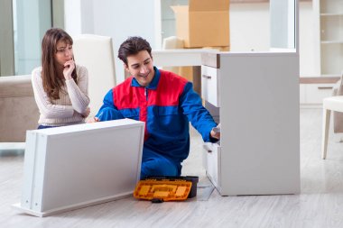 Müteahhit kadın gözetiminde mobilya montajı yapıyor.