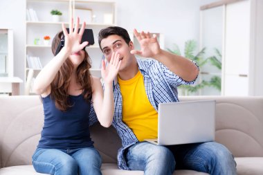 Genç bir aile sanal gerçeklik gözlükleriyle oyun oynuyor.