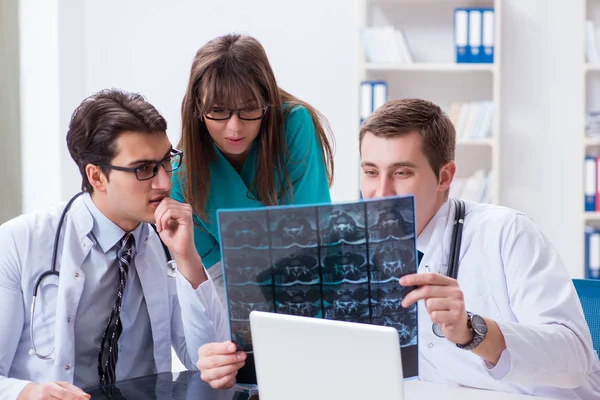 Tres médicos discutiendo los resultados de la exploración de la imagen de rayos X — Foto de Stock