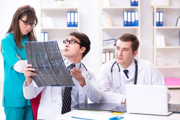 Drie artsen bespreken scanresultaten van röntgenfoto 's — Stockfoto