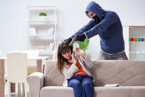 Озброєний чоловік нападає на молоду жінку вдома — стокове фото