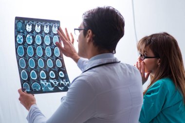 Üç doktor röntgen sonuçlarını tartışıyor