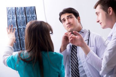 Üç doktor röntgen sonuçlarını tartışıyor