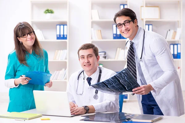 Tres médicos discutiendo los resultados de la exploración de la imagen de rayos X — Foto de Stock