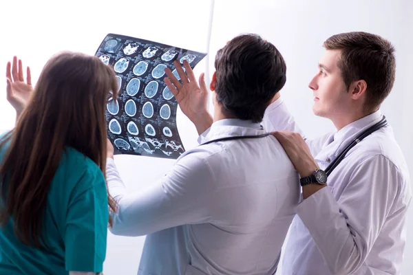 Tre läkare diskuterar skanningsresultat av röntgenbild — Stockfoto