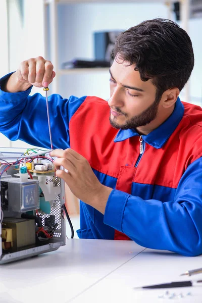 Jonge reparateur repareren en repareren microgolfoven — Stockfoto