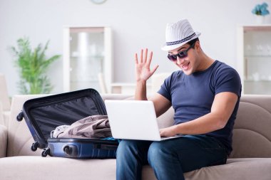 İnternet üzerinden seyahat ve otel rezervasyonu yapan bir adam.