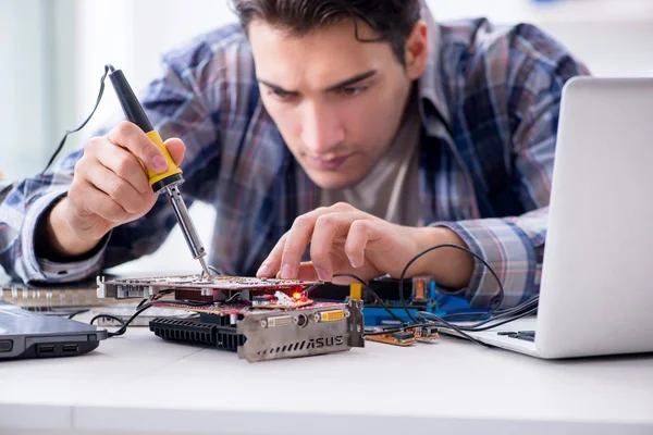 Professional repairman repairing computer in workshop