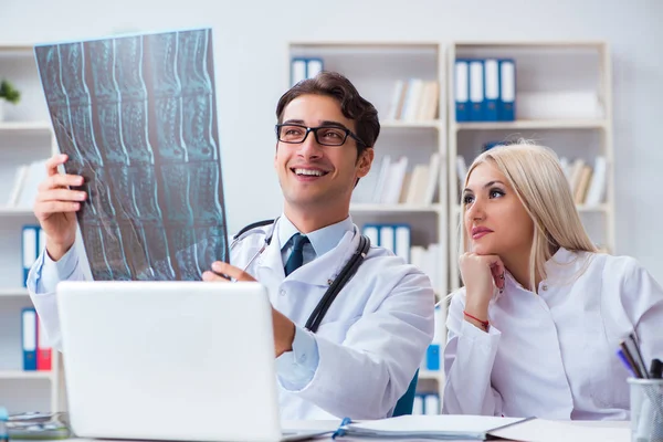 Dos médicos examinando imágenes de rayos X del paciente para su diagnóstico —  Fotos de Stock