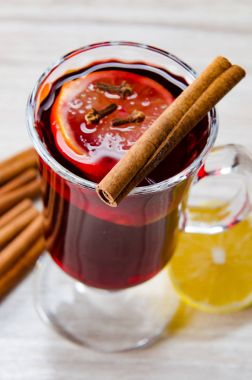 Haşlanmış şarap, yılbaşı masasında servis edilen bardaklarda parlıyor.