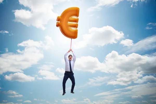 Uomo d'affari che vola su euro segno palloncino gonfiabile — Foto Stock