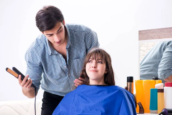 Мужчина парикмахер стрижется для женщины — стоковое фото