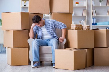 Genç adam kutularla yeni eve taşınıyor.