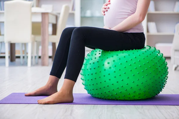 Hamile kadın çocuk doğurma beklentisiyle egzersiz yapıyor. — Stok fotoğraf