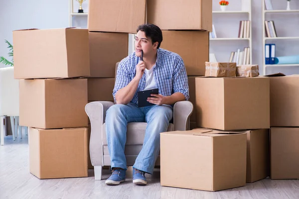 Jeune homme emménageant dans une nouvelle maison avec des boîtes — Photo