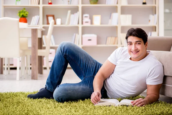 Hombre leyendo libro en casa en el suelo — Foto de Stock