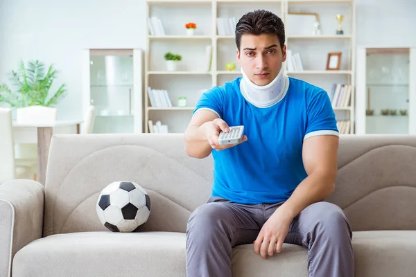 Hombre con lesión en el cuello viendo fútbol fútbol en casa —  Fotos de Stock