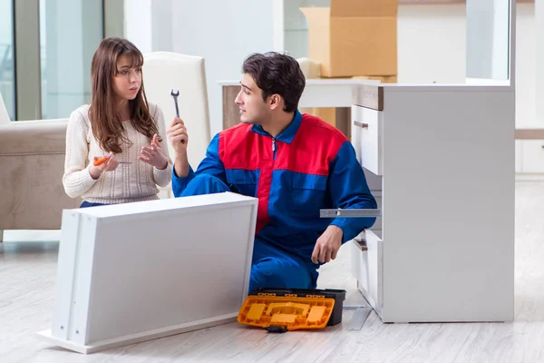 Bauunternehmer repariert Möbel unter weiblicher Aufsicht — Stockfoto