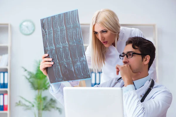 Två läkare undersöker röntgenbilder av patienten för diagnos — Stockfoto