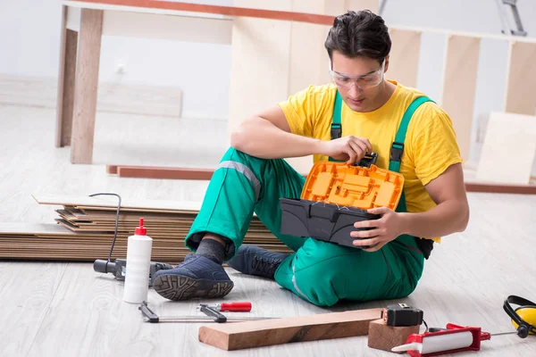 Contratista trabajando en piso de madera laminado — Foto de Stock