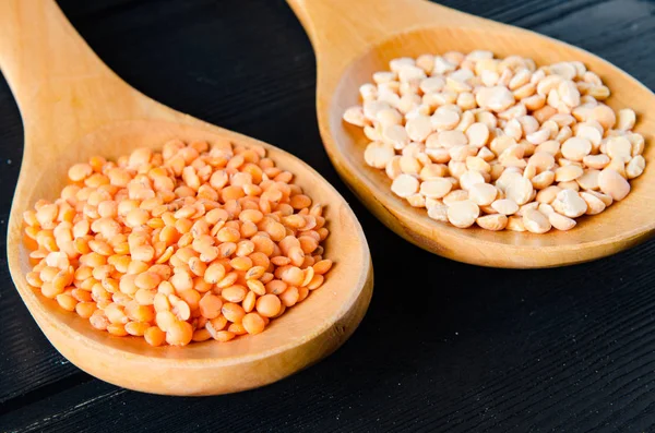 Spoons filled with uncooked lentil for soup — Stock Photo, Image