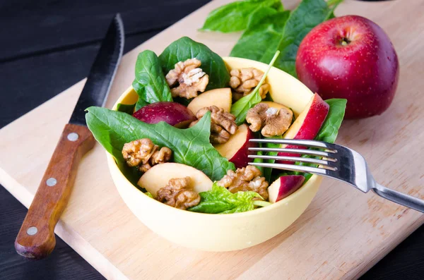 Salada de espinafre com nozes e maçãs servidas na mesa — Fotografia de Stock