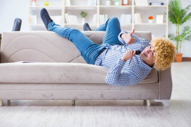 Evde karaoke yapan komik adam.