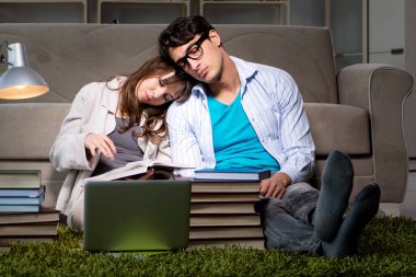 İki öğrenci geç saatlere kadar çalışıp sınavlara hazırlanıyor.