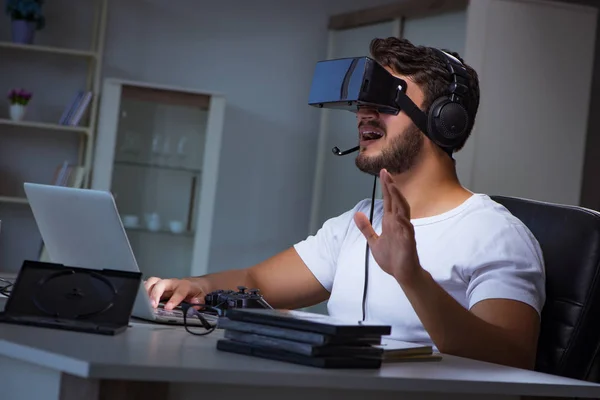 Jovem jogando jogos longas horas atrasado no escritório — Fotografia de Stock