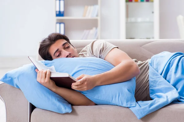 Junger Student bereitet sich mit Buch im Bett auf College-Prüfungen vor — Stockfoto