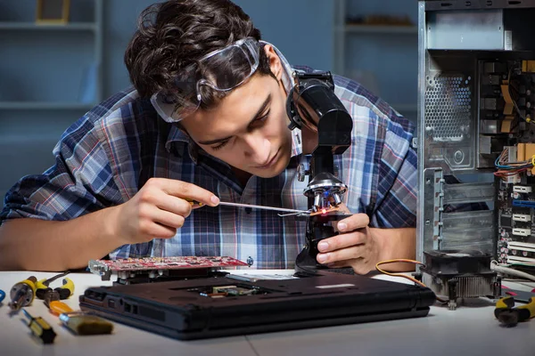 Reparateur versucht Laptop mit Mikroskop zu reparieren — Stockfoto