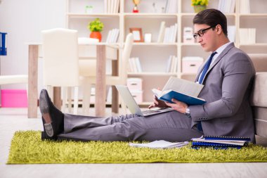 İş adamı evde yerde çalışıyor.