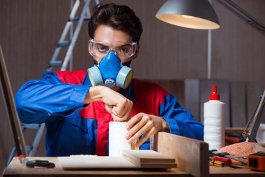 Genç adam ahşap parçaları DIY konseptinde yapıştırıyor.