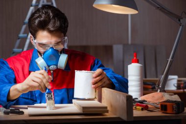Genç adam ahşap parçaları DIY konseptinde yapıştırıyor.