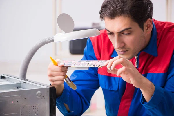 Professional repairman repairing computer in workshop