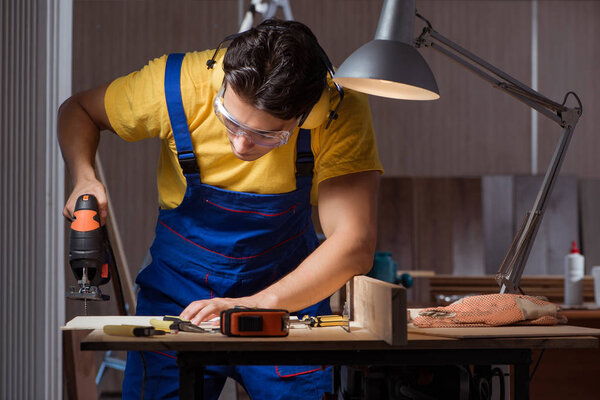 Worker working in repair workshop in woodworking concept