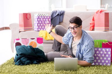 Genç adam internetten kıyafet alıyor ve blog yönetiyor.