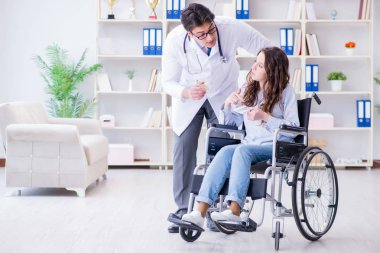 Tekerlekli sandalyedeki hasta düzenli kontrol için doktoru ziyaret ediyor.