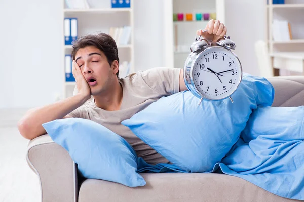 Man having trouble waking up with alarm clock